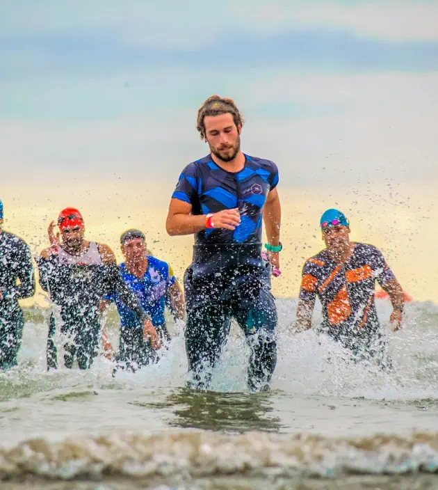 entrenador triatlon triatletas saliendo del mar